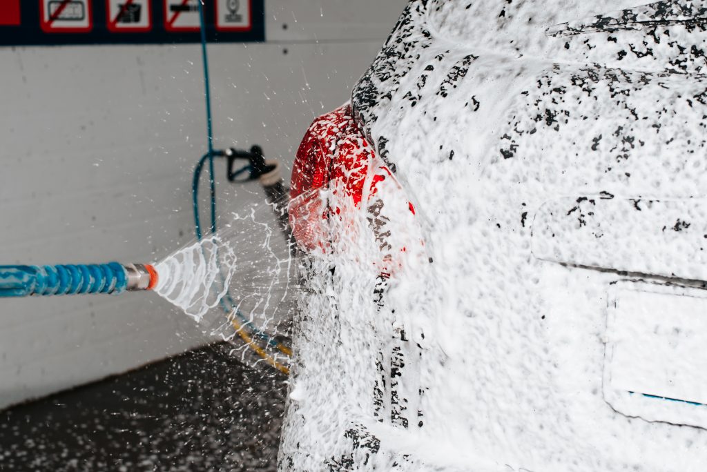 car wash, headlight cleaning with high pressure foam close up. selective focus
